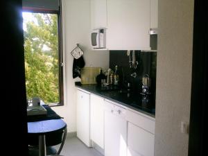 a kitchen with white cabinets and a black counter top at Apartment Troia Garden in Troia +6 photos