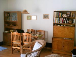 uma sala de estar com mesa e cadeiras e uma estante de livros em Apartment Troia Garden em Tróia