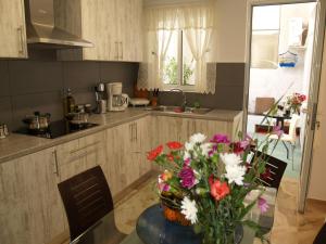 a kitchen with a table with a vase of flowers on it at Brigitte house in Chania Town