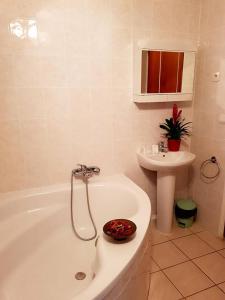 a bathroom with a bath tub and a sink at Hôtel**résidence BEAR in Port-Vendres
