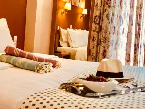a hotel room with a table with a hat on a bed at G George in Nydri