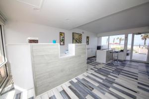 a living room with white walls and wooden floors at Beach House Inn in Daytona Beach