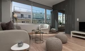 アテネにあるAthens City Center Apartmentのソファと椅子とテレビのあるリビングルーム