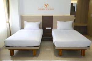 Postel nebo postele na pokoji v ubytování Vignesh Residency