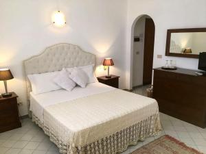 a bedroom with a bed and a dresser and a television at Hotel O Palmo in Panarea