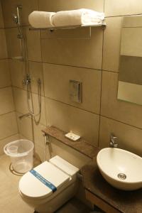 y baño con aseo, lavabo y ducha. en Vignesh Residency en Tiruchchirāppalli