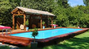 a swimming pool with a gazebo in a yard at Campagne Baudeloup in L'Isle-sur-la-Sorgue