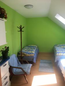 a green room with two beds and a chair at Objekt Nizna in Nižná