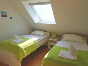 Duas camas num pequeno quarto com uma janela em Ferienwohnung Nordwind em Cuxhaven