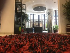 a lobby with a large rug on the floor at Plasma Hotel Tripoli in Tripoli