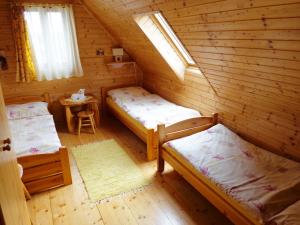 - une chambre avec 2 lits dans une cabane en rondins dans l'établissement Drevenica Deni, à Osturňa
