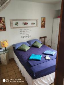 1 dormitorio con 1 cama con sábanas y almohadas azules en Ap. do LeoSan, en João Pessoa