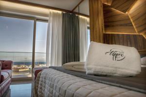 ミラッツォにあるUpper - Boutique Hotelの枕付きのベッドと窓のある寝室