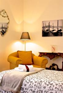 ヴェネツィアにあるCasa Giulianaのベッドルーム(ベッド1台、黄色のソファ付)