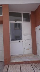 a garage with two white doors on a brick wall at Blue Apartment in Portimão