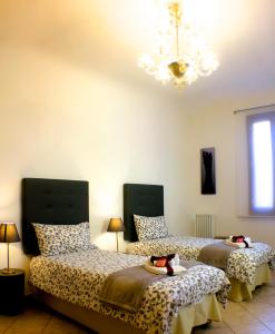 ヴェネツィアにあるCasa Giulianaのベッドルーム1室(ベッド2台、シャンデリア付)