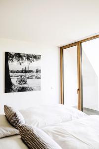 a white bedroom with a large bed and a window at Hotel Lenderstuben in Balzhausen