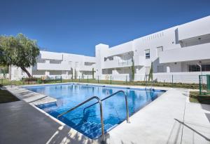 a swimming pool in front of a building at La Reserva Puerto Banus in Marbella