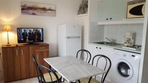 a kitchen with a table and chairs in a kitchen at Résidence d'Azur 2 311 appartement climatisé in Le Lavandou +9 photos