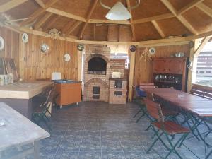 a kitchen with a brick fireplace and tables and chairs at Pensiunea BRADU in Piatra Neamţ