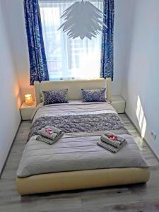 オラデアにあるHighsky Oradea Apartmentsのベッドルーム1室(青いカーテン付きの大型ベッド1台付)