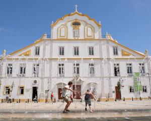 two people playing in a fountain in front of a building at Blue Apartment in Portimão
