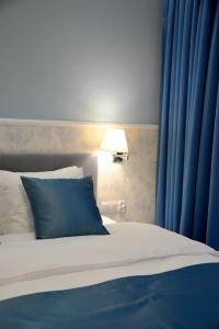 sypialnia z łóżkiem z niebieskimi zasłonami i lampką w obiekcie JessApart – Ochota Apartments w Warszawie