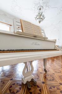 ein weißes Klavier in einem Zimmer mit einer Decke in der Unterkunft The Grand Piano Villa in Kutaissi