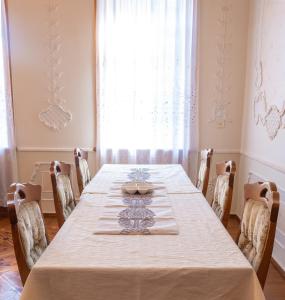 un comedor con una mesa larga y sillas en The Grand Piano Villa, en Kutaisi
