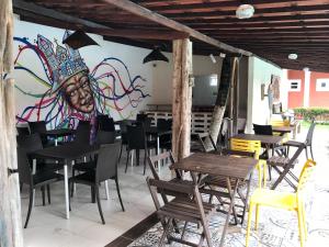 ein Wandbild an der Wand eines Restaurants mit Tischen und Stühlen in der Unterkunft Pousada das Araras in Maceió