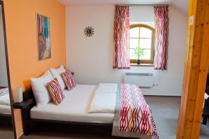 - une chambre avec un lit doté d'oreillers rouges et blancs dans l'établissement Penzion Krásný sklep, à Znojmo