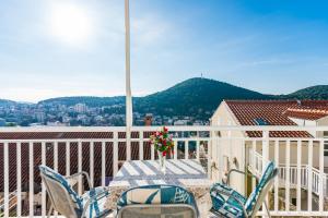 una mesa y sillas en un balcón con vistas en Guest House Nenada, en Dubrovnik
