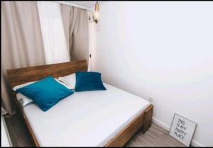 a bed with two blue pillows in a room at Šuština in Tribunj