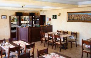 a restaurant with tables and chairs and a bar at Family hotel Elena in Arbanasi