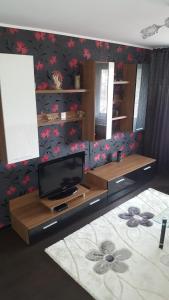 ein Wohnzimmer mit einem TV und einem Tisch in der Unterkunft Apartament Matei in Constanţa