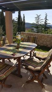 Une table et des chaises en bois sont disponibles sur la terrasse. dans l'établissement Villa Mio Mare, à Cres