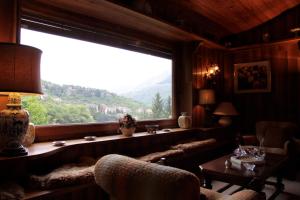 a living room with a large window and a table at Le Rocce di Scanno B&B di Charme in Scanno