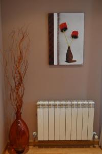 a room with a vase and a picture and a vase with flowers at Apartamento Nuevo Baztan in Elizondo