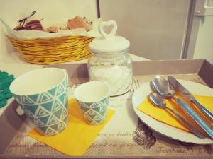 a tray with two cups and a plate and a glass jar at Profumo di Casa in Santa Giustina
