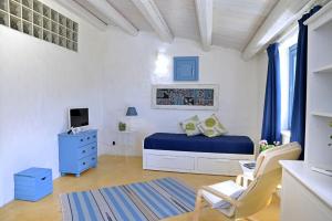 a white bedroom with a blue bed and a blue dresser at B&B Scacciapensieri in Castellammare del Golfo