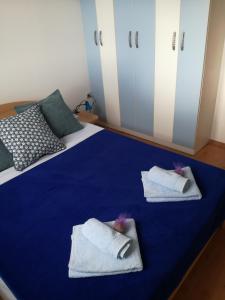ein blaues Bett mit zwei weißen Handtüchern drauf in der Unterkunft Apartments Blue House in Korčula