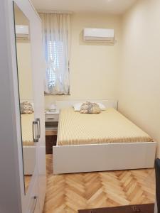 een kleine slaapkamer met een bed en een raam bij Studio Apartman San in Split