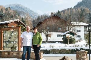 Ein Mann und eine Frau stehen vor einem Haus in der Unterkunft Gasthof Mühlwinkl in Staudach-Egerndach