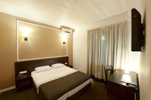 Cette chambre comprend un lit et un bureau. dans l'établissement Geneva Resort Hotel, à Odessa
