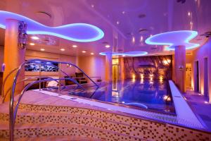 einen Whirlpool in einem Zimmer mit lila Beleuchtung in der Unterkunft Hotel Ambiente Wellness & Spa in Karlsbad