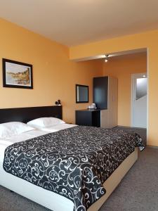 a bedroom with a large bed with a black and white comforter at Boruna Guest House in Sozopol