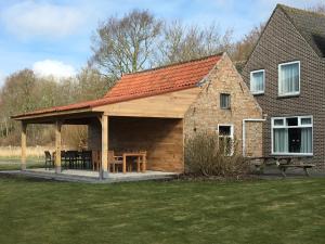 einem Pavillon mit einem Picknicktisch vor einem Haus in der Unterkunft de Paardenmarkt in Aardenburg