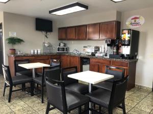 a restaurant with two tables and a kitchen with a counter at Super 8 by Wyndham Casa Grande in Casa Grande