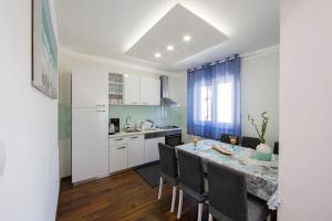 a kitchen and dining room with a table and chairs at Apartment Tina in Split