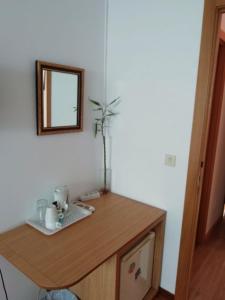a wooden desk with a mirror and a laptop on it at Hospedaje Lopez in A Coruña